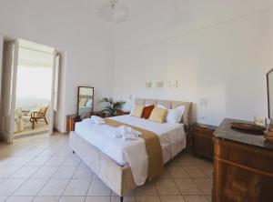 a bedroom with a large bed and a balcony at Syrenia Home in Vico Equense