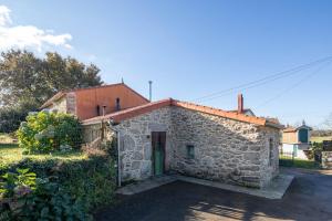 a stone house with a door in a yard at La Caseta De Laura in Arzúa