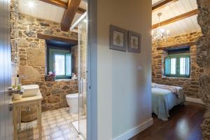 a bathroom with a sink and a toilet in a room at La Caseta De Laura in Arzúa
