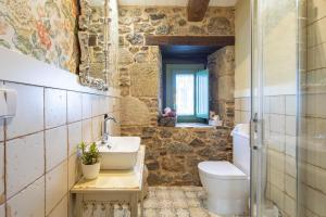 a bathroom with a sink and a toilet at La Caseta De Laura in Arzúa