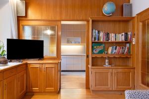 a living room with a television and a book shelf at Appartamento Cesa Wanker in Ortisei
