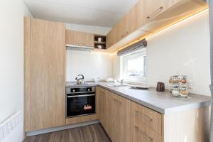 a kitchen with wooden cabinets and a black oven at Haus Laura in Untergriesbach