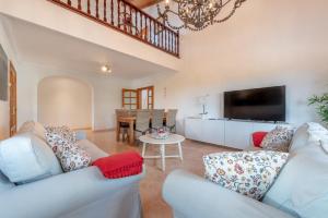 a living room with two couches and a tv at Es Cantó in Cala Llombards