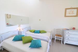 a bedroom with two beds and a dresser and a mirror at Casa Vacanza Primitivo di Manduria in Otranto
