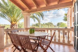 a patio with a table and chairs on a balcony at Es Cantó in Cala Llombards