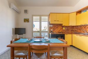 a kitchen with a wooden table with chairs and a dining room at Vista Mare in Santa Croce Camerina