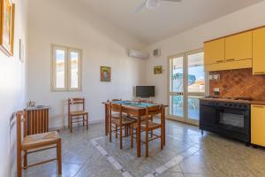 a kitchen with a table and chairs and a kitchen with yellow cabinets at Vista Mare in Santa Croce Camerina