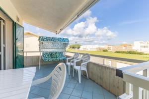 a balcony with a table and chairs and an umbrella at Vista Mare in Santa Croce Camerina