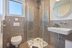 a bathroom with a shower and a toilet and a sink at Egge Resort 7c mit Whirpool u Sauna in Altenbeken +12 photos