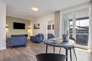 a living room with a table and chairs and a couch at Egge Resort 7c mit Whirpool u Sauna in Altenbeken