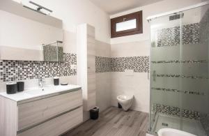 a bathroom with a sink and a toilet and a shower at Villetta farfalle in Sarroch +18 photos