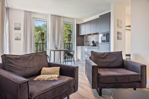 a living room with a couch and chairs and a kitchen at Egge Resort 7c mit Whirpool u Sauna in Altenbeken