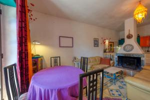 a living room with a purple table and a fireplace at Sprocketlandia in Frigole +37 photos