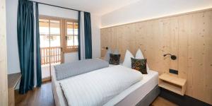 a bedroom with a white bed and a window at Himml Schlosshof in Völs am Schlern