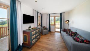 a living room with a couch and a television at Himml Schlosshof in Völs am Schlern
