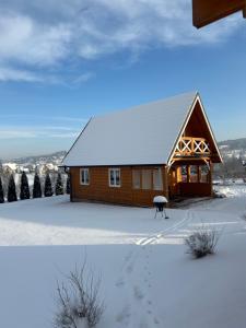 a house covered in snow with footprints in the snow at Dolina Skawy in Skawa