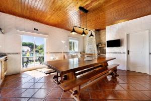 a dining room with a wooden table and a window at Villa Oliveira in Aljezur