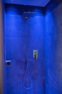 a blue bathroom with a shower with a hose at Himml Schlosshof in Völs am Schlern +22 photos
