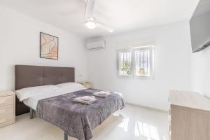 a white bedroom with a bed and two windows at Villa Andes in Benissa +22 photos