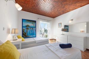 a bedroom with a white bed and a large window at Villa Oliveira in Aljezur +22 photos