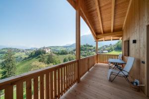 a wooden balcony with a desk and chair on it at Himml Schlosshof in Völs am Schlern