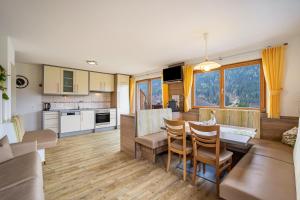 a kitchen and living room with a table and chairs at Stoffnerhof Apt Sonnenblume in Tesido