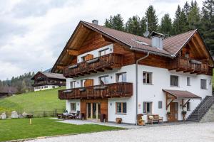 a house with wooden balconies on a hill at Stoffnerhof Apt Sonnenblume in Tesido
