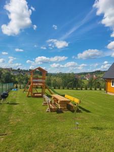 a park with a wooden swing set in the grass at Dolina Skawy in Skawa