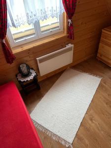 a living room with a red couch and a white rug at Dolina Skawy in Skawa