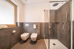 a bathroom with a toilet and a shower at Apt Eiche - Nockerhof in Andrian