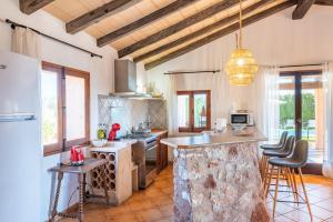 a kitchen with an island in the middle of a room at Ses Oliveres in Campos