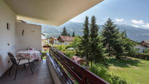 a balcony with a table and chairs and mountains at Schnitzer Ferienwohnung Hagebutte in Rablà