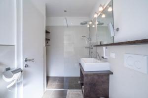 a white bathroom with a sink and a mirror at Schnitzer Ferienwohnung Hagebutte in Rablà +18 photos