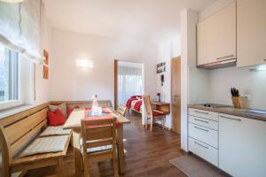 a kitchen and living room with a table and a dining room at Schnitzer Ferienwohnung Hagebutte in Rablà