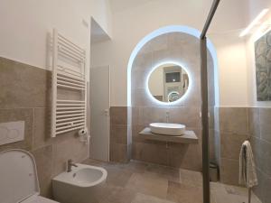 a bathroom with a sink and a toilet and a mirror at Syrenia Home in Vico Equense +37 photos