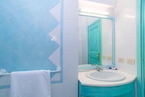 a bathroom with a sink and a mirror at Conchiglia Blu in Barrabisa +17 photos