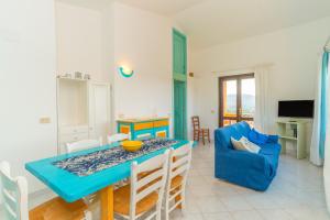 a living room with a blue table and a blue chair at Conchiglia Blu in Barrabisa