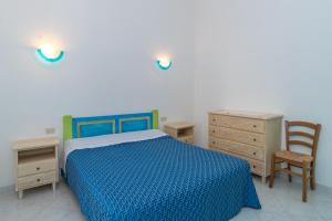 a bedroom with a bed and a desk and a chair at Conchiglia Blu in Barrabisa