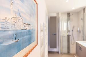 a bathroom with a painting of a ship on the wall at Ferienwohnung Butjes in Sollwitt +25 photos