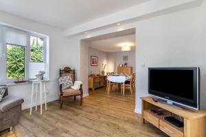 a living room with a television and a dining room at Ferienwohnung Butjes in Sollwitt