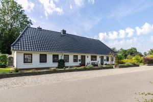 a white house with a black roof on a road at Ferienwohnung Butjes in Sollwitt