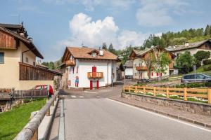 a street in a village with houses and a bridge at Appartamento Le Coccinelle in Varena