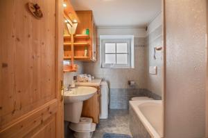 a bathroom with a sink and a toilet and a tub at Appartamento Le Coccinelle in Varena +14 photos