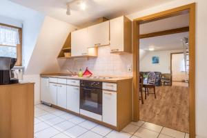 a kitchen with white cabinets and a stove top oven at Ferienwohnung Nr 2 in Deggenhausertal