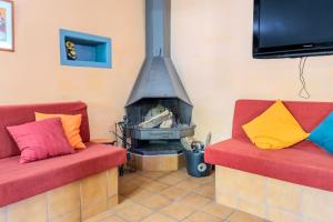 a living room with two red chairs and a fireplace at Can Mestrehumà in Bas
