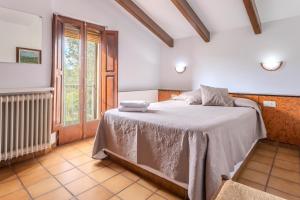 a bedroom with a bed in a room with a window at Can Mestrehumà in Bas +22 photos