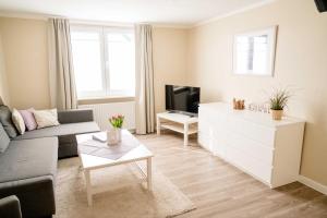 a living room with a couch and a tv at Bauernhof Marquardt in Fehmarn