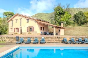 a house with a swimming pool in front of a house at Can Mestrehumà in Bas