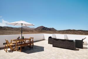 a patio with a table and chairs and an umbrella at Brisa 3 in La Santa