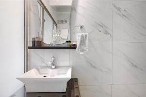 a white bathroom with a sink and a mirror at Villa Drosia in Volímai +21 photos